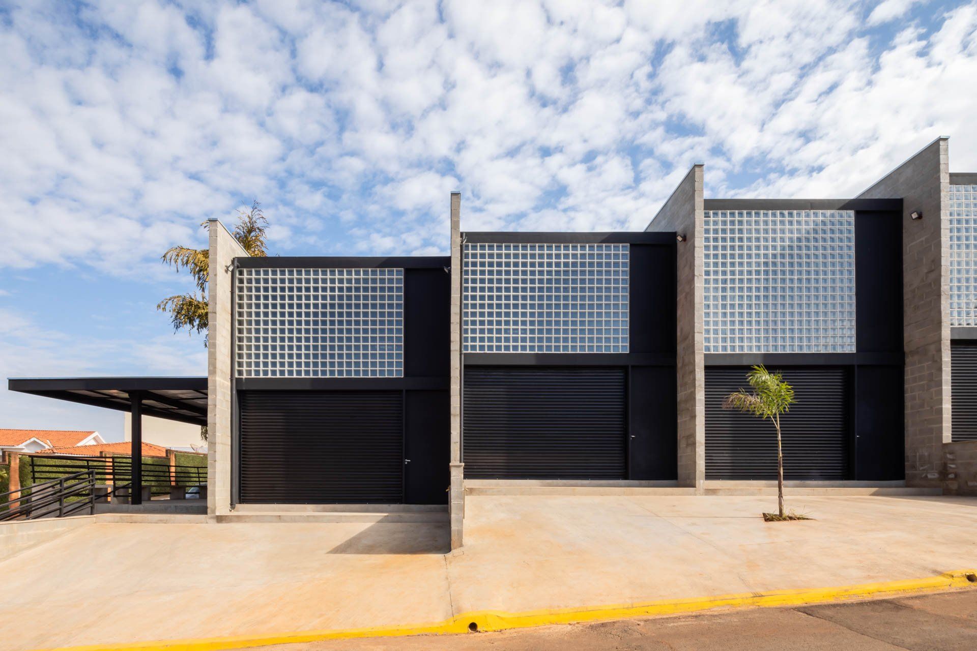 Uma casa moderna com muitas janelas e uma árvore na frente.