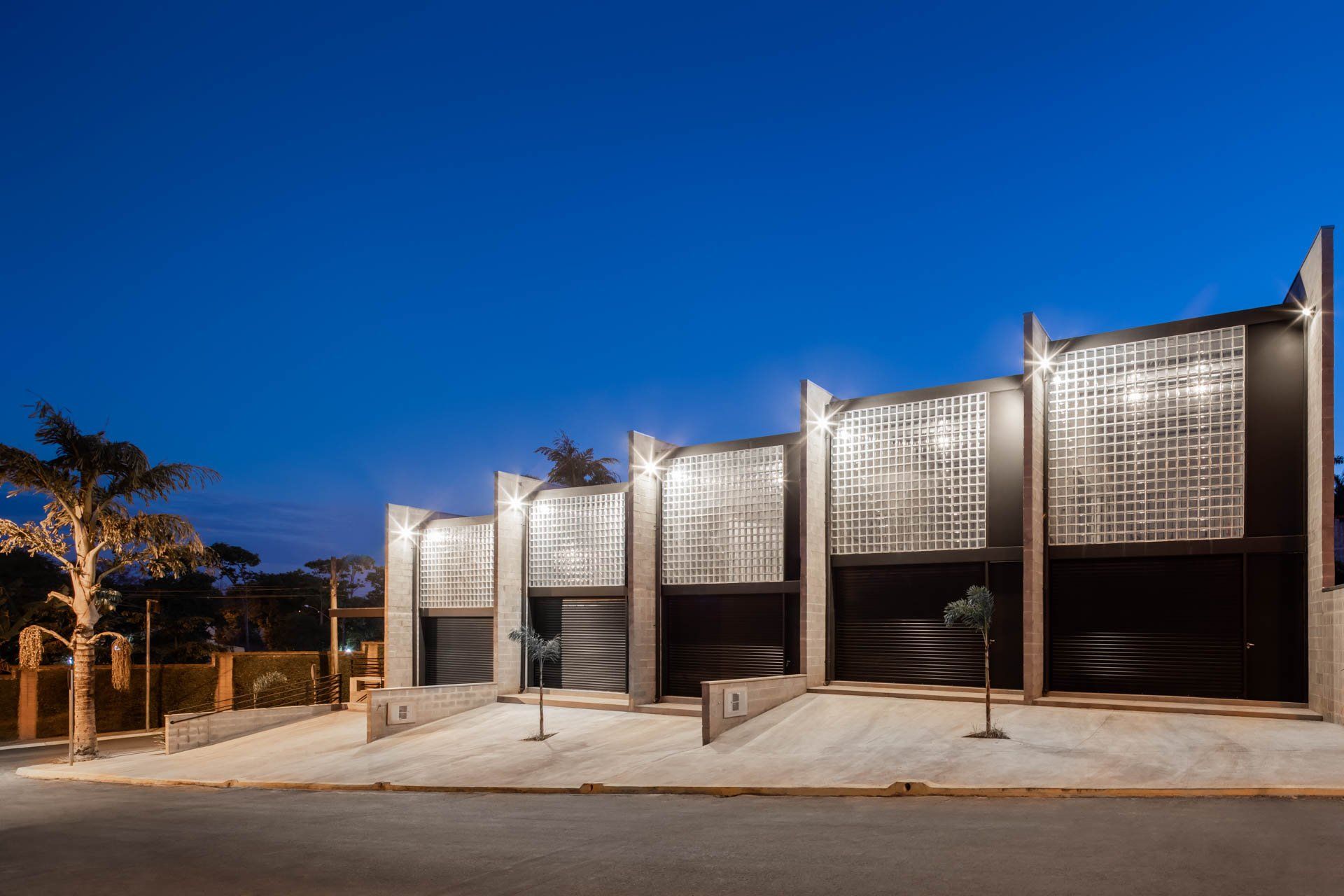 Um prédio com muitas garagens fica iluminado à noite.