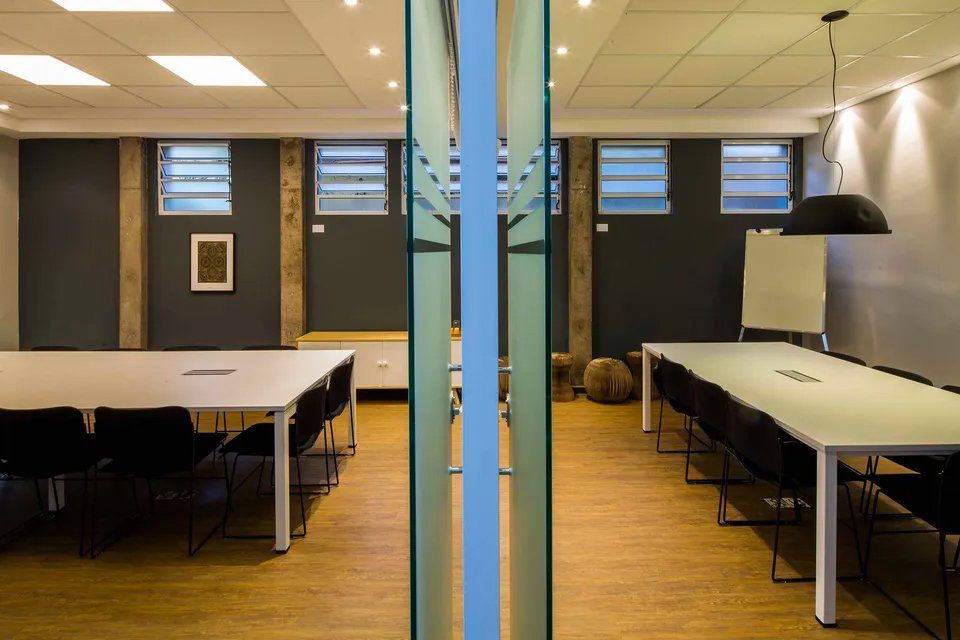 Uma sala de conferências com uma longa mesa e cadeiras