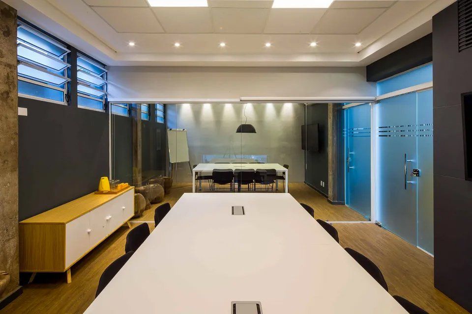 Uma sala de conferências com uma longa mesa e cadeiras