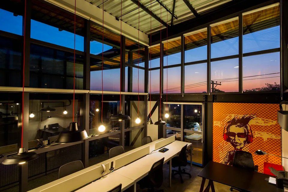 Um grande escritório com muitas janelas e uma pintura na parede.