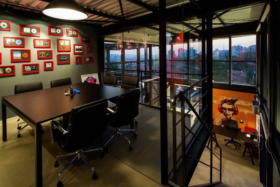 Uma sala de conferências com mesa e cadeiras e uma pintura na parede.