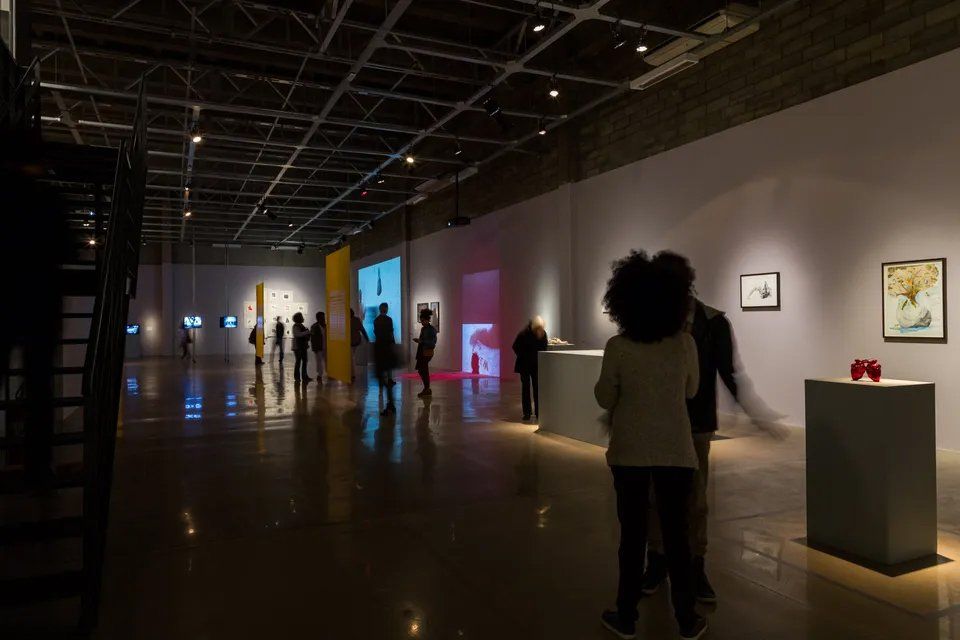 Um grupo de pessoas está em uma grande sala de um museu.