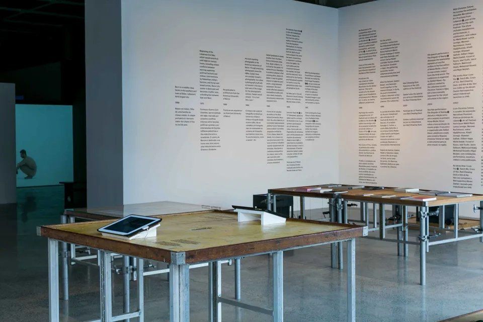 Uma sala com muitas mesas e uma parede branca