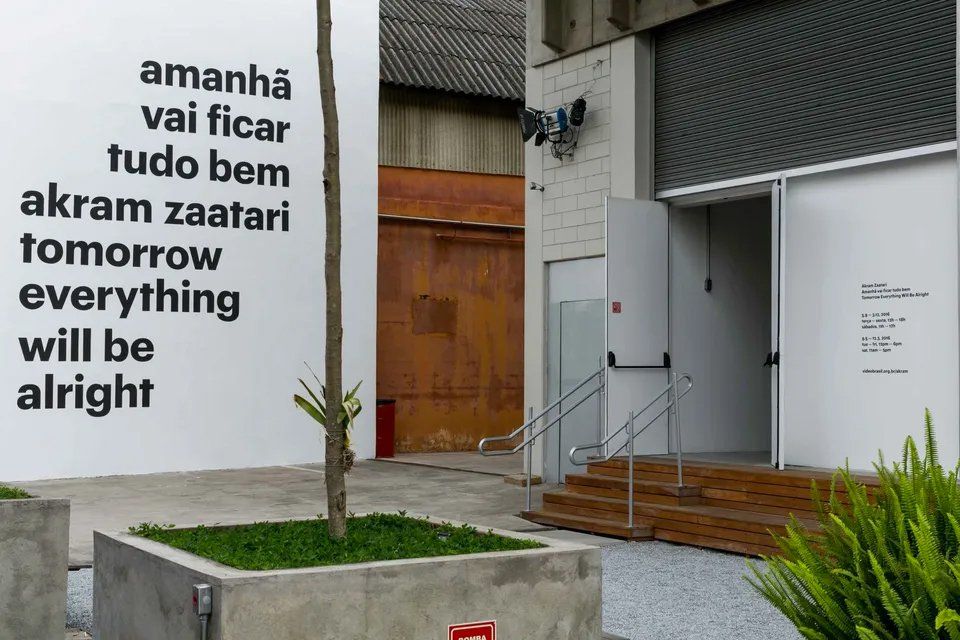 Um prédio branco com uma placa que diz que tudo ficará bem