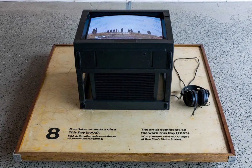 Uma TV e fones de ouvido estão em uma mesa de madeira com o número 8