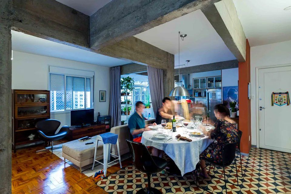 Um grupo de pessoas está sentado à mesa de uma sala de estar.