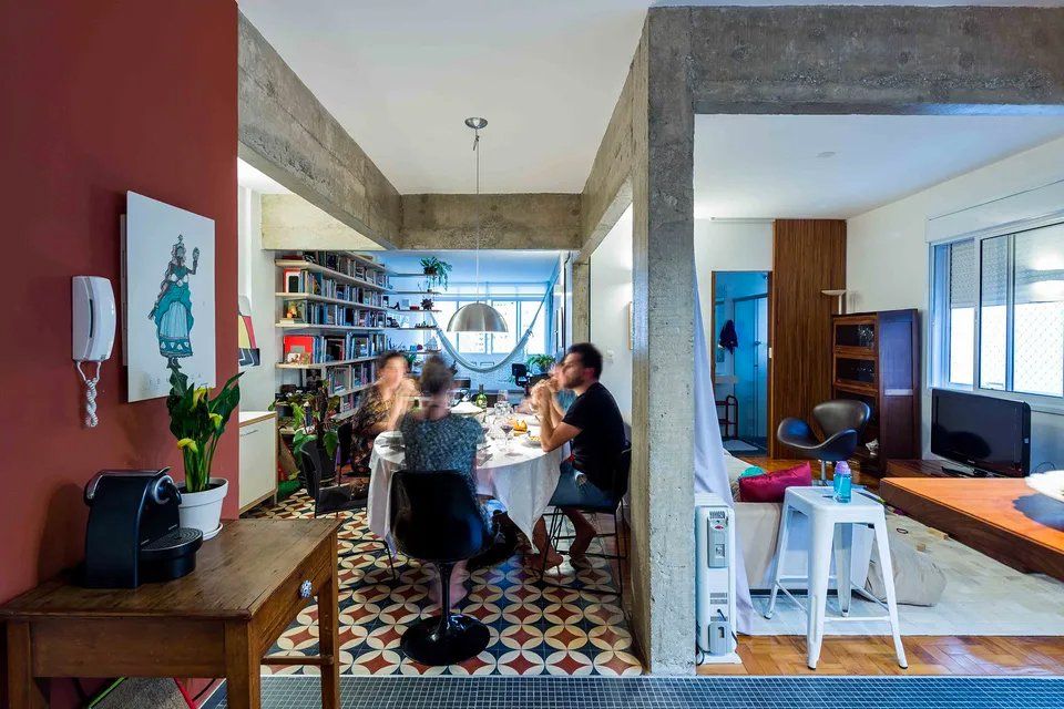 Um grupo de pessoas está sentado à mesa de uma sala de estar.