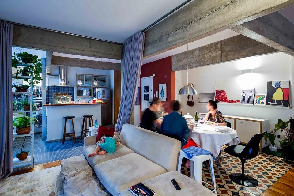 Um grupo de pessoas está sentado em um sofá na sala de estar.