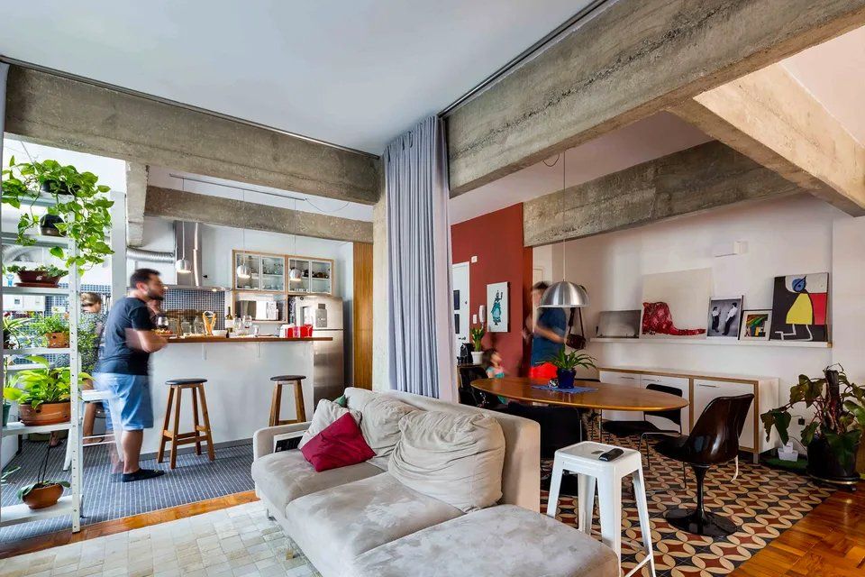 Um homem está parado em uma sala ao lado de um sofá.