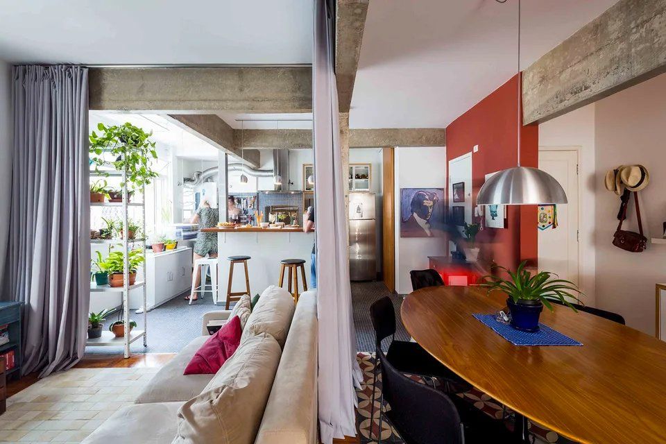 Uma sala com sofá, mesa e cadeiras.