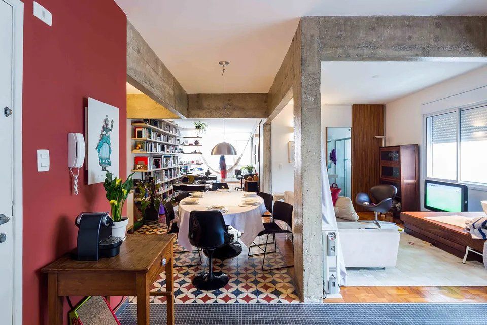 Há uma mesa e cadeiras no meio da sala.