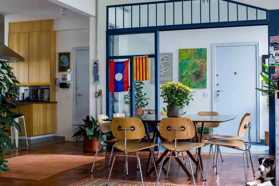 Uma sala de jantar com mesa e cadeiras e um cachorro.