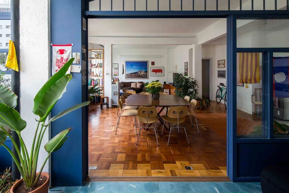 Uma sala de estar com mesa e cadeiras e porta de vidro deslizante.