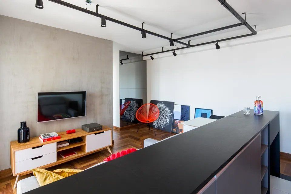 Uma sala de estar com TV de tela plana na parede.