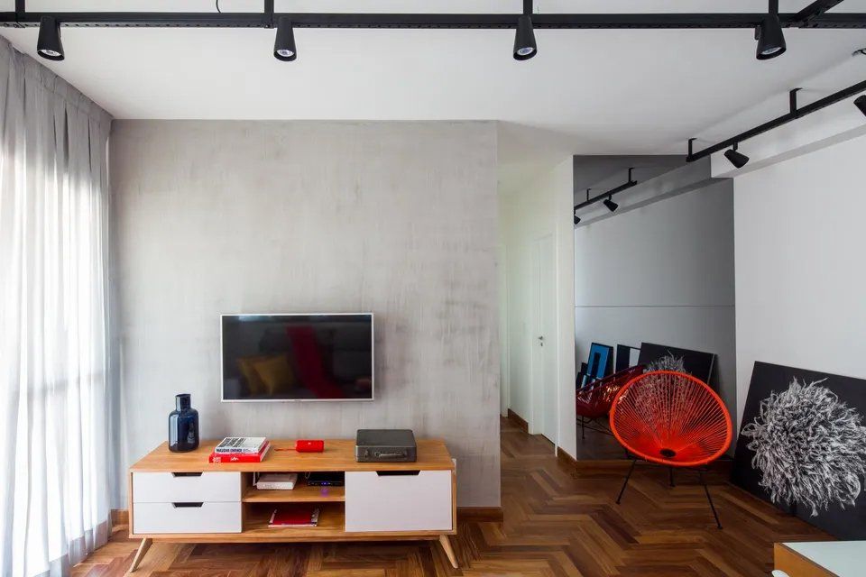 Uma sala de estar com TV de tela plana na parede.