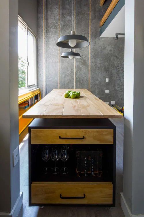 Uma cozinha com uma longa mesa de madeira e gavetas.