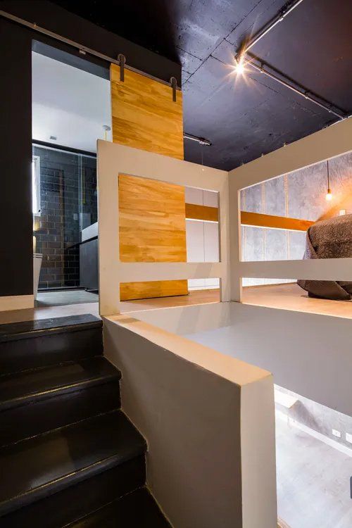 Um quarto com beliche e escadas que levam até ele.