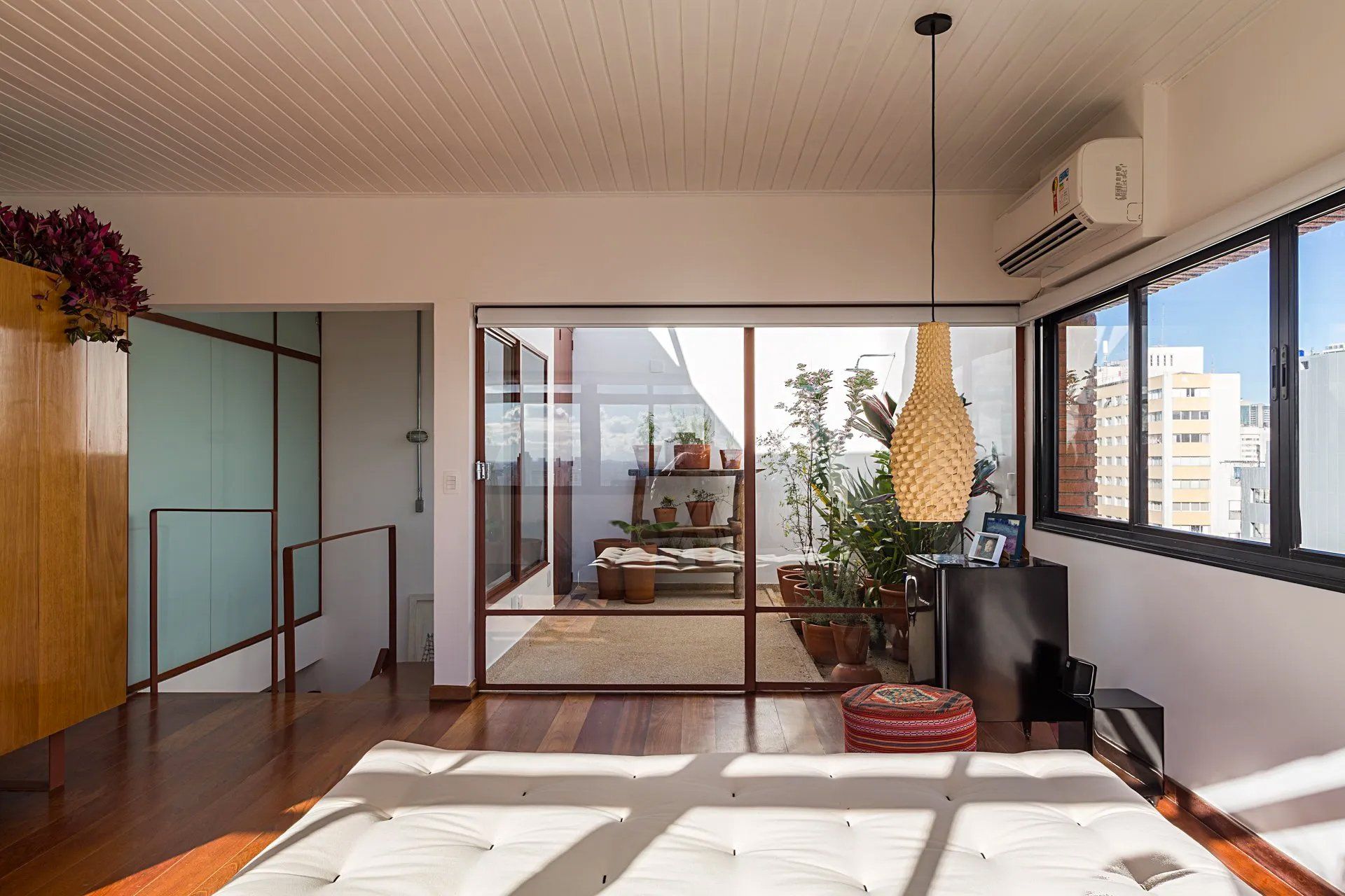 Uma sala de estar com sofá e muitas janelas