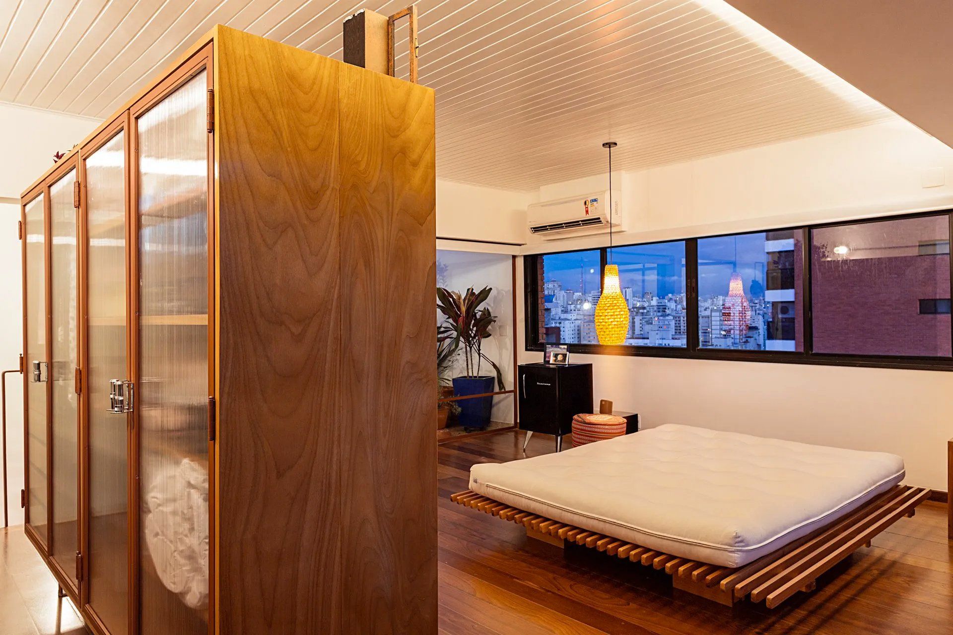 Um quarto com uma cama grande e muitas janelas