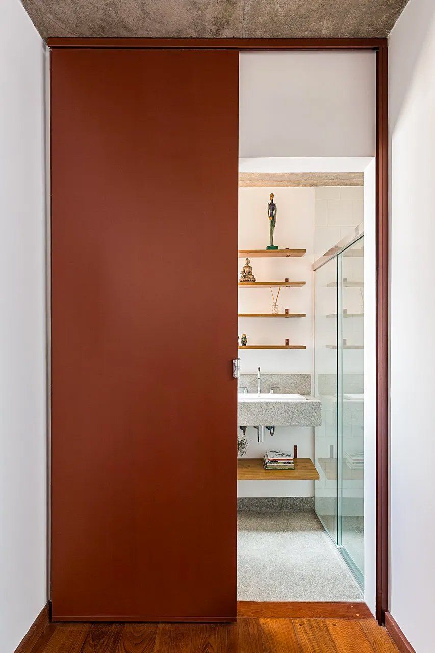 Uma casa de banho com lavatório e uma porta de correr que dá acesso a ela.