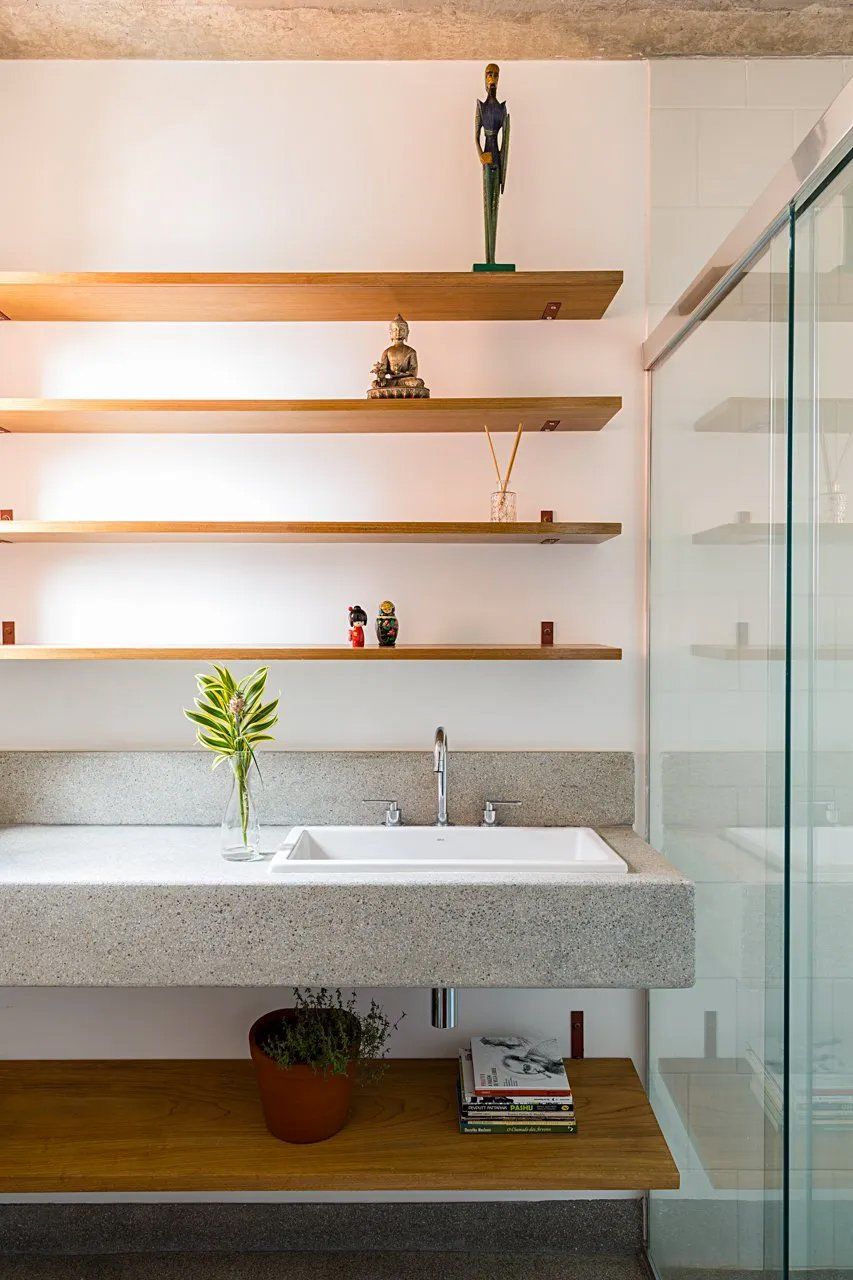 Um banheiro com pia e prateleiras acima