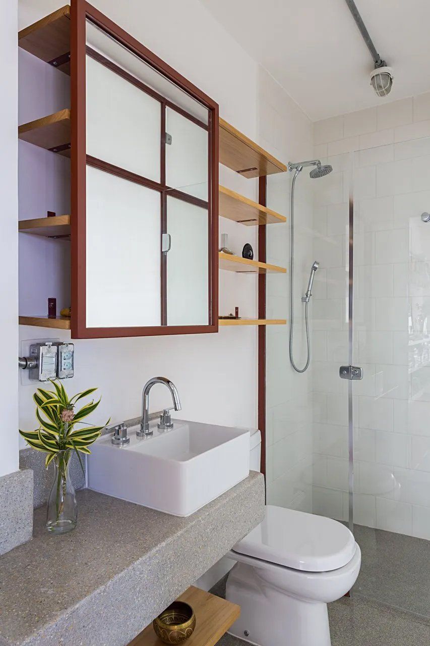 Um banheiro com pia, vaso sanitário e chuveiro.