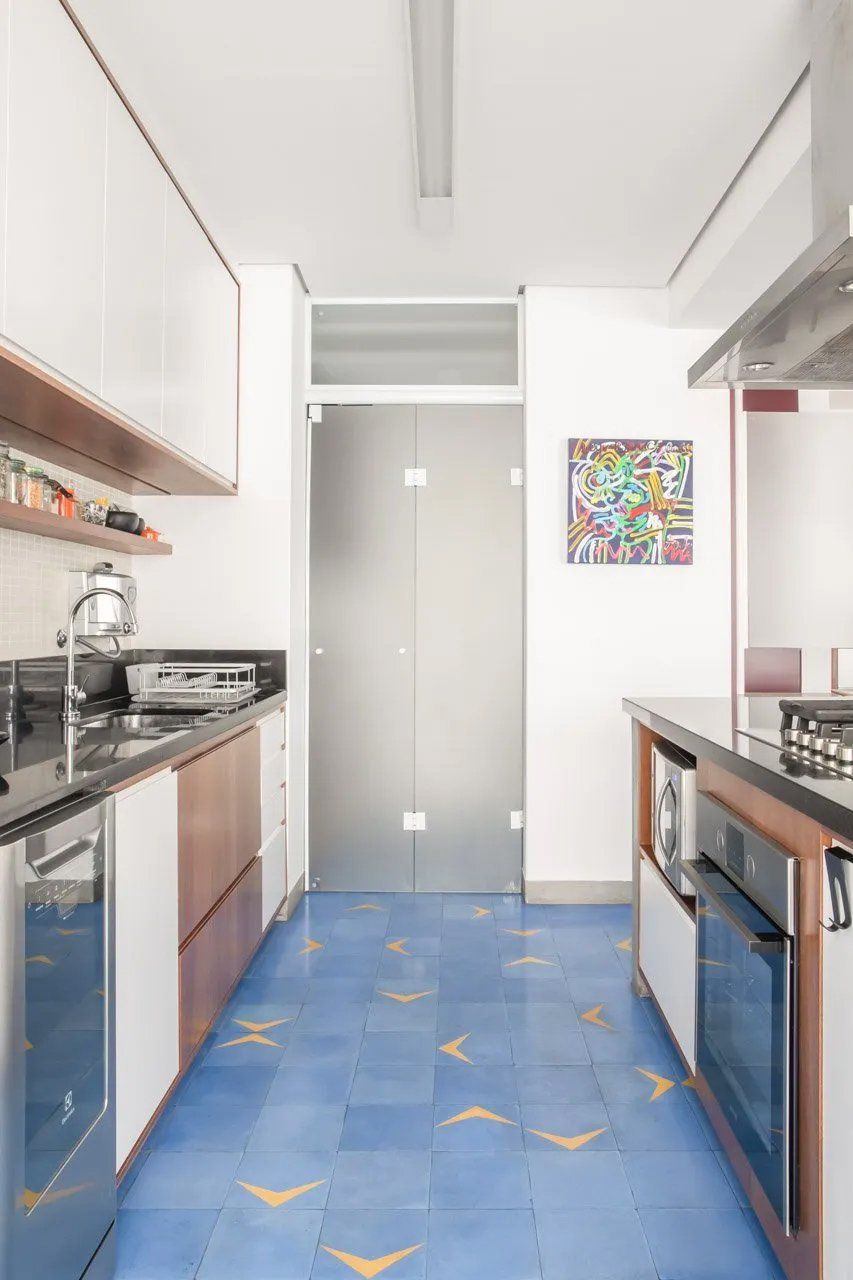 Uma cozinha com piso de cerâmica azul e uma pintura na parede