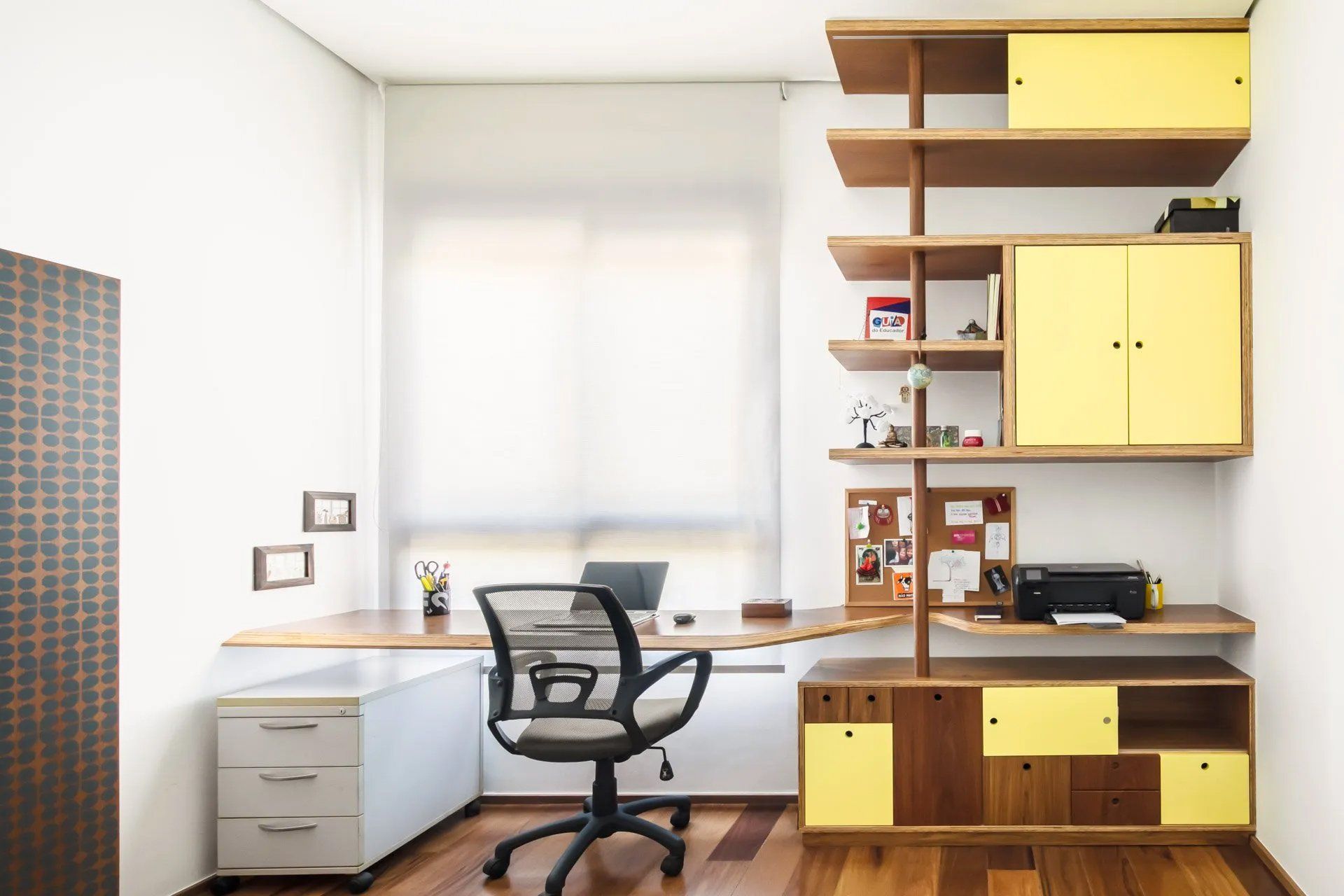 Um home office com mesa, cadeira, estantes e impressora.