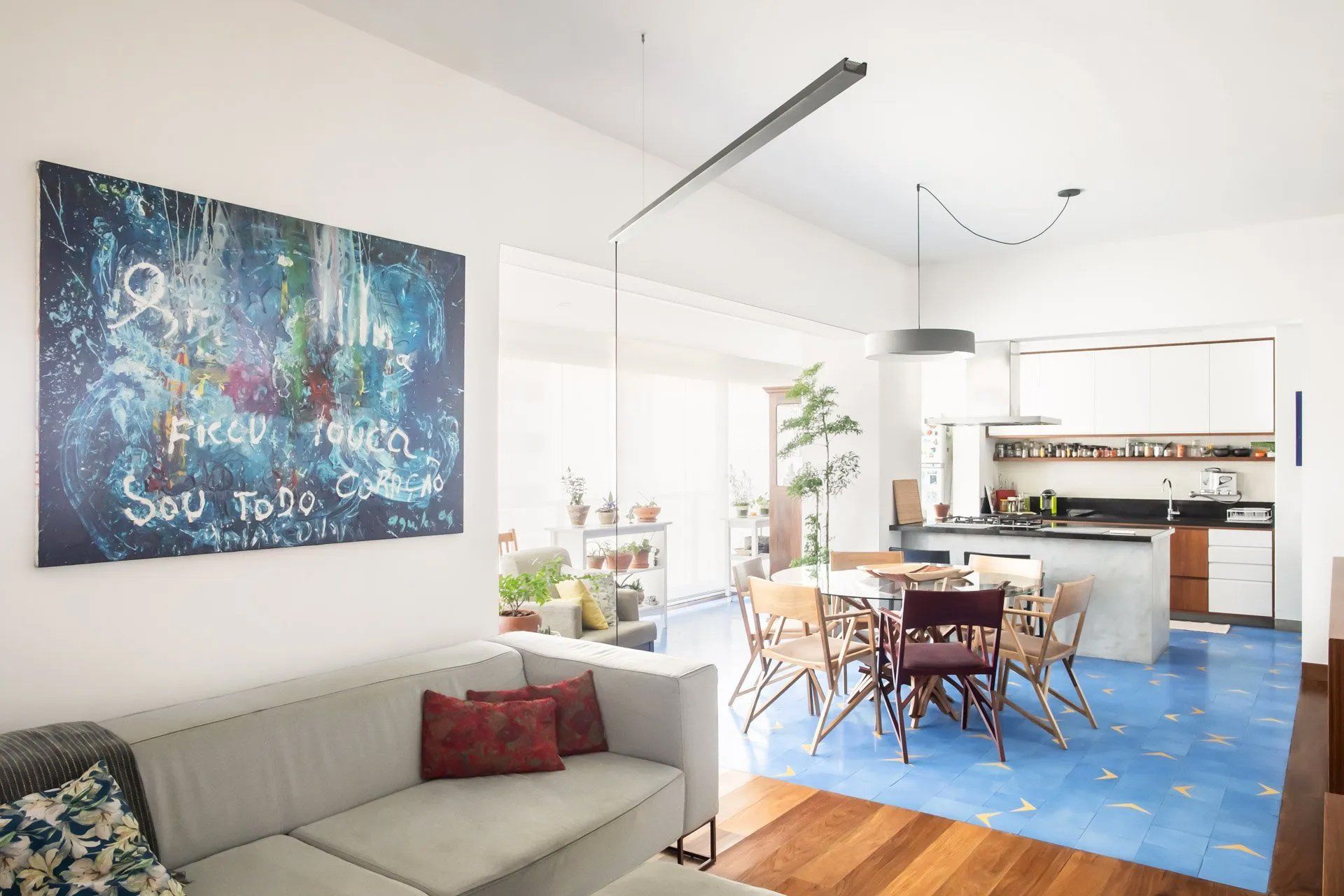 Uma sala com sofá e um quadro na parede.