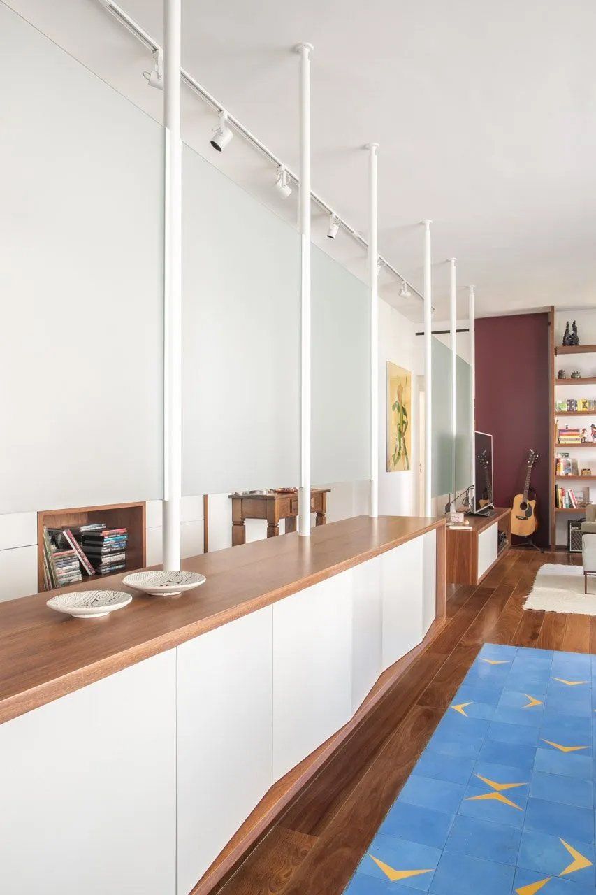 Uma sala com tapete azul e armários brancos