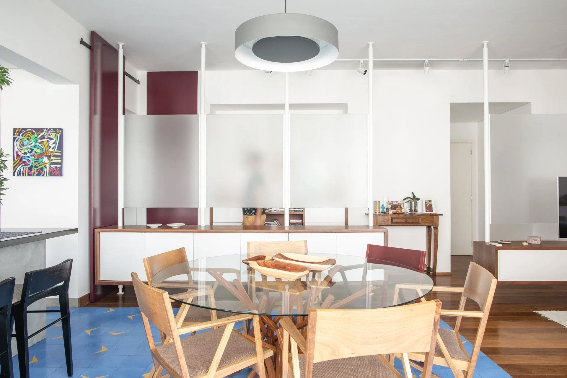 Uma sala de jantar com mesa e cadeiras de vidro.