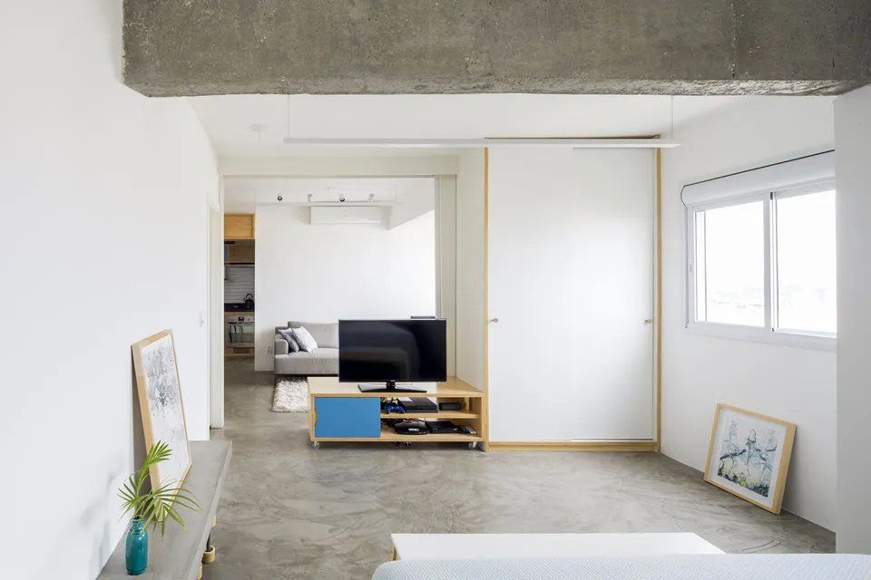 Uma sala de estar com TV de tela plana e sofá.