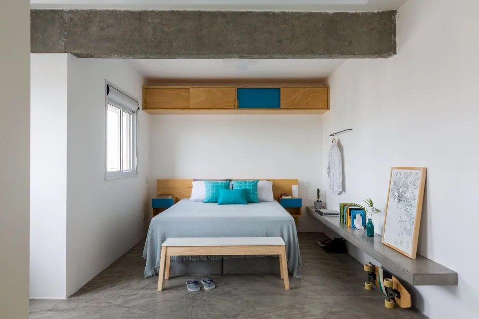 Um quarto com uma cama e um banco.