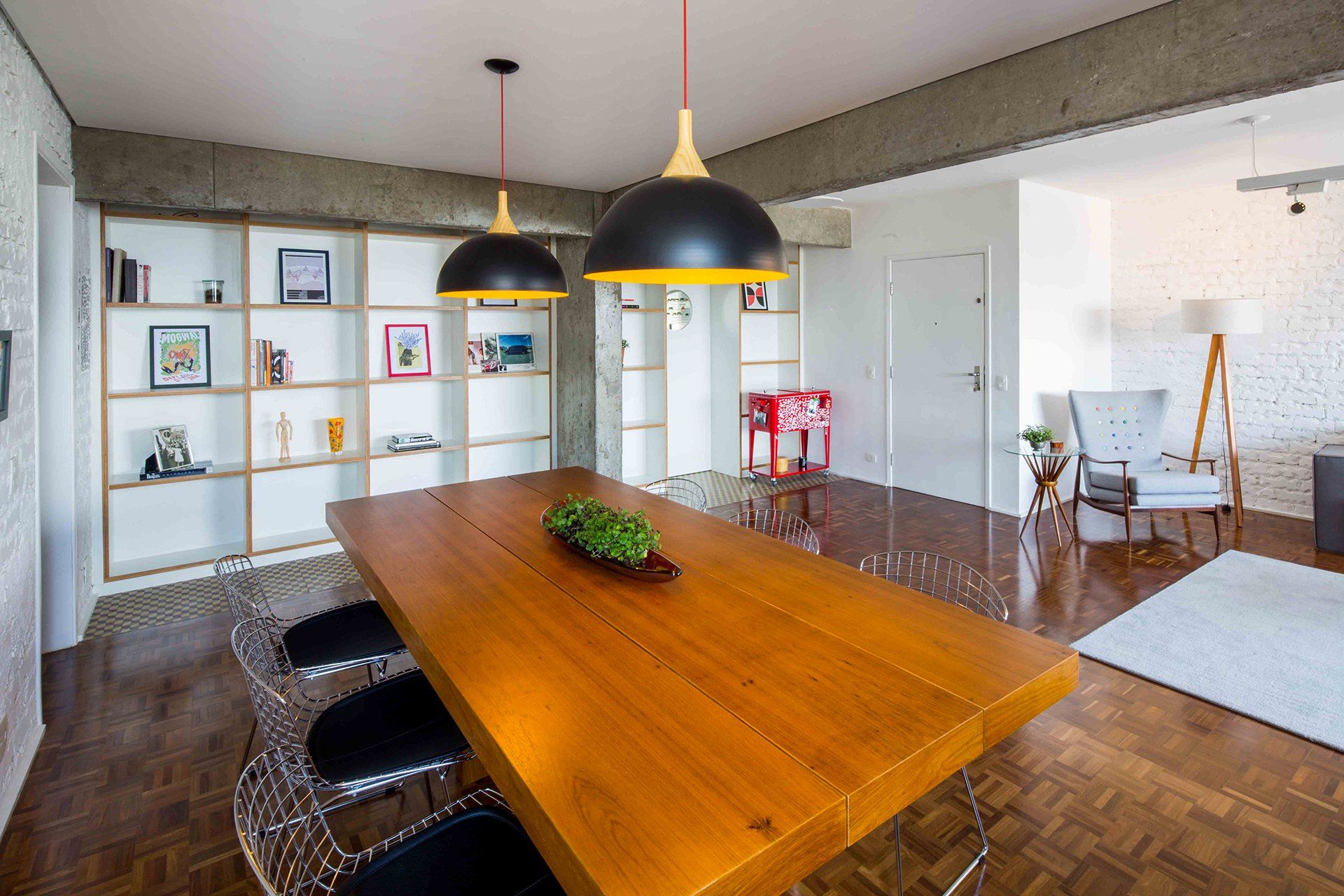 Há uma longa mesa de madeira no meio da sala.