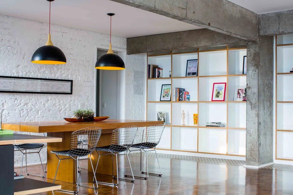 Há uma mesa e cadeiras no meio da sala.