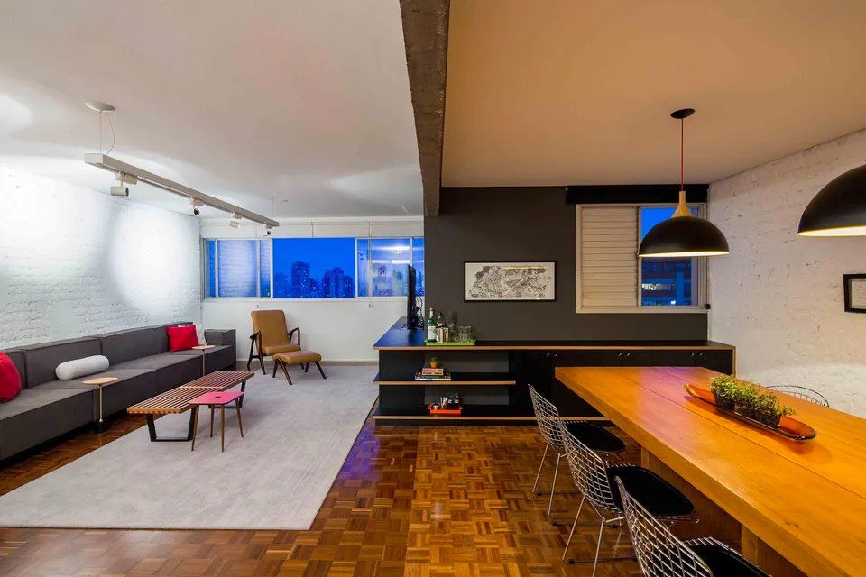 Uma sala com sofá, mesa e cadeiras.