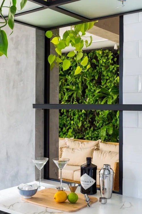 Um balcão de cozinha com uma garrafa de gim Hendrick's e duas taças de martini.