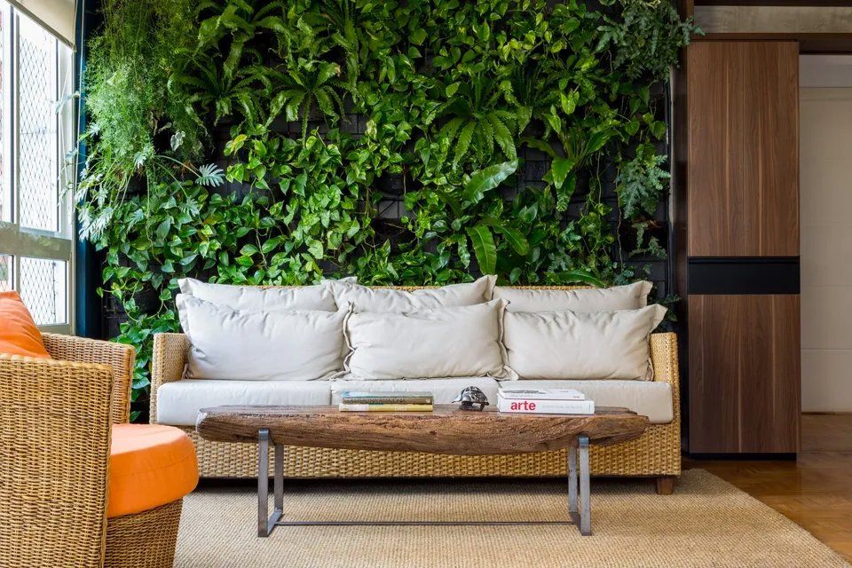 Uma sala com sofá, cadeira, mesa de centro e parede verde.