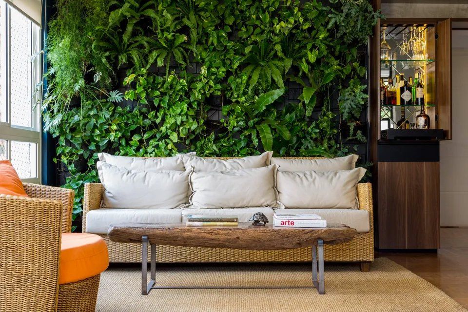 Uma sala com sofá, cadeira, mesa e parede verde.