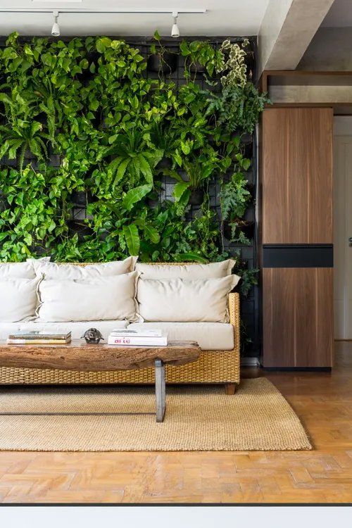 Uma sala de estar com sofá, mesa de centro e parede verde.