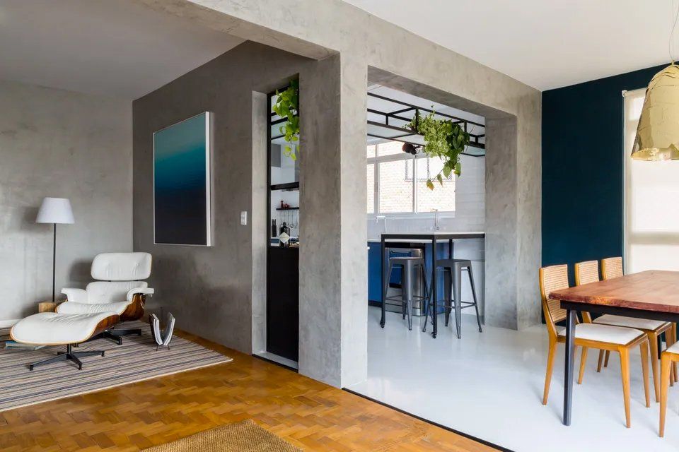 Uma sala de estar com mesa e cadeiras e uma sala de jantar com mesa e cadeiras.