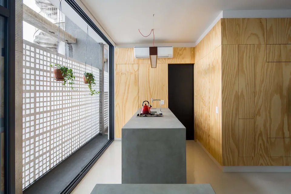 Uma cozinha com uma grande ilha e uma grande janela.