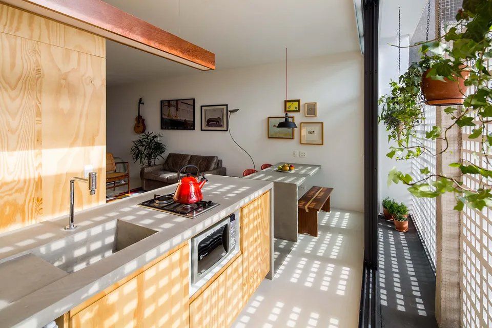 Uma cozinha com armários de madeira, pia, fogão e mesa.