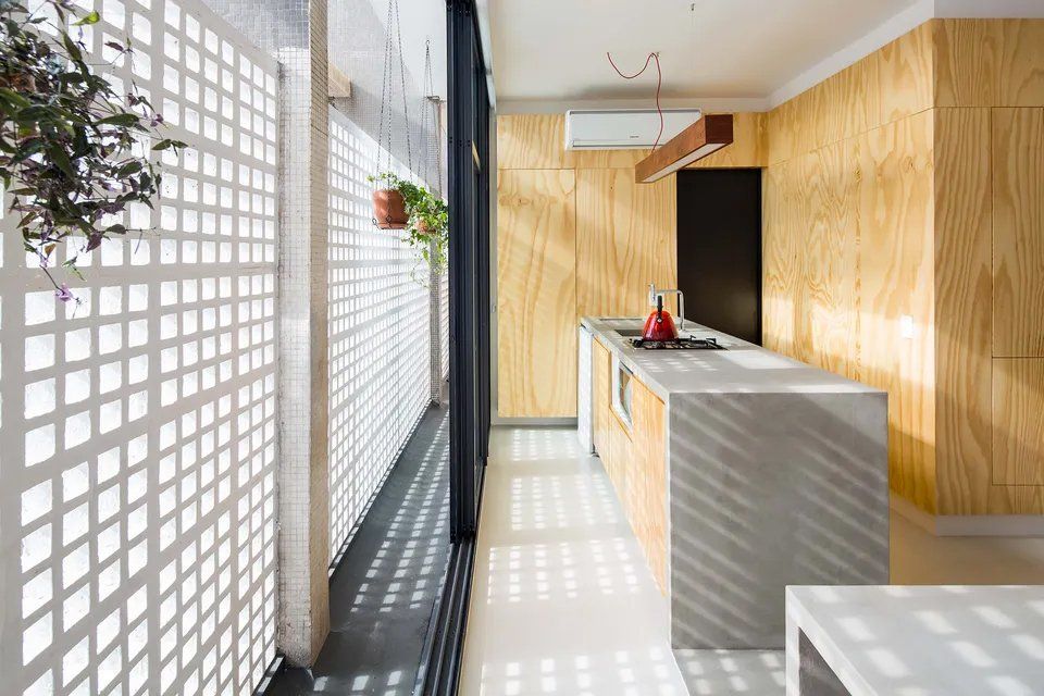 Uma cozinha com porta de correr em vidro e paredes em madeira.