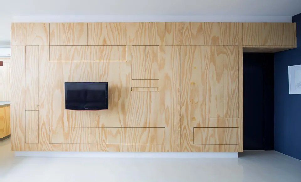 Uma parede de madeira com uma TV de tela plana montada nela.