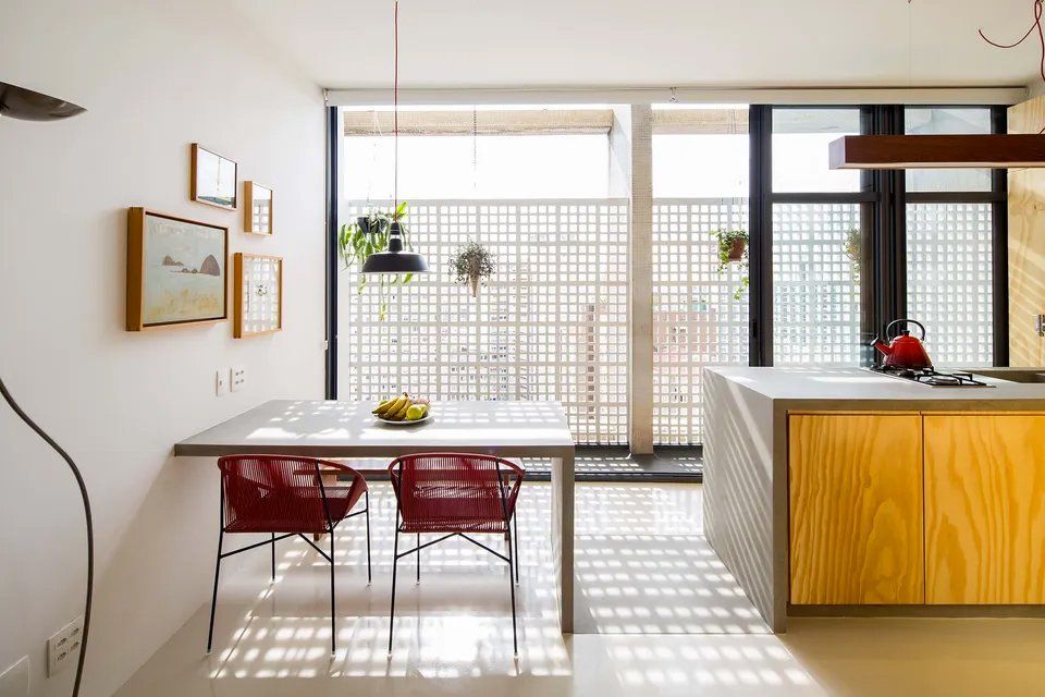 Uma cozinha com mesa e cadeiras e uma grande janela.