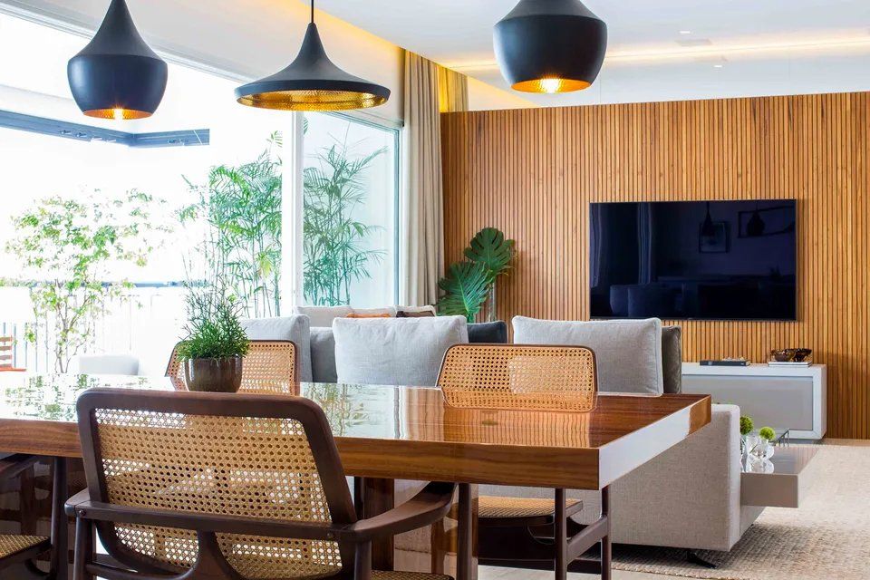 Uma sala de estar com mesa de jantar e cadeiras e uma TV de tela plana.