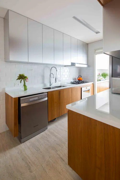 Uma cozinha com armários de madeira e eletrodomésticos em inox.