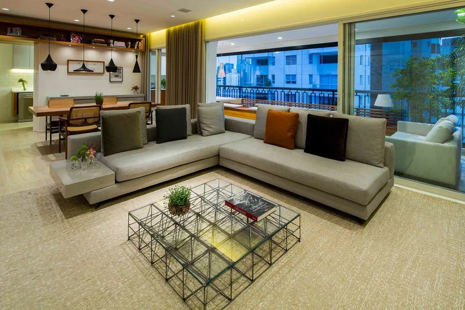 Uma sala de estar com um sofá grande e uma mesa de centro de vidro